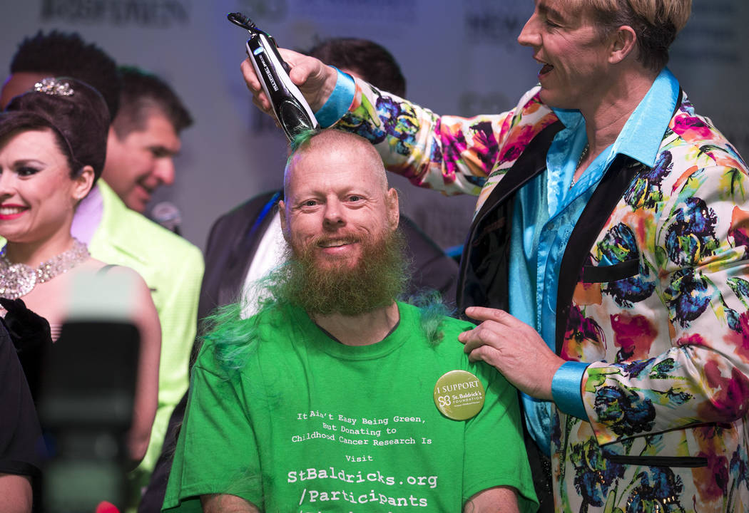 Ed Conte, a crew member for Cirque du Soleil's "Zumanity," gets his head shaved during the St. Baldrick's head-shaving event to raise money for childhood cancer research outside the New York-New Y ...