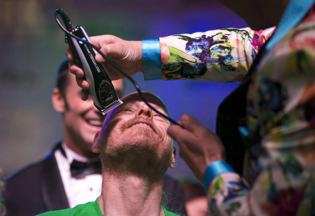 Ed Conte, a crew member for Cirque du Soleil's "Zumanity," gets his head shaved during the St. Baldrick's head-shaving event to raise money for childhood cancer research outside the New York-New Y ...
