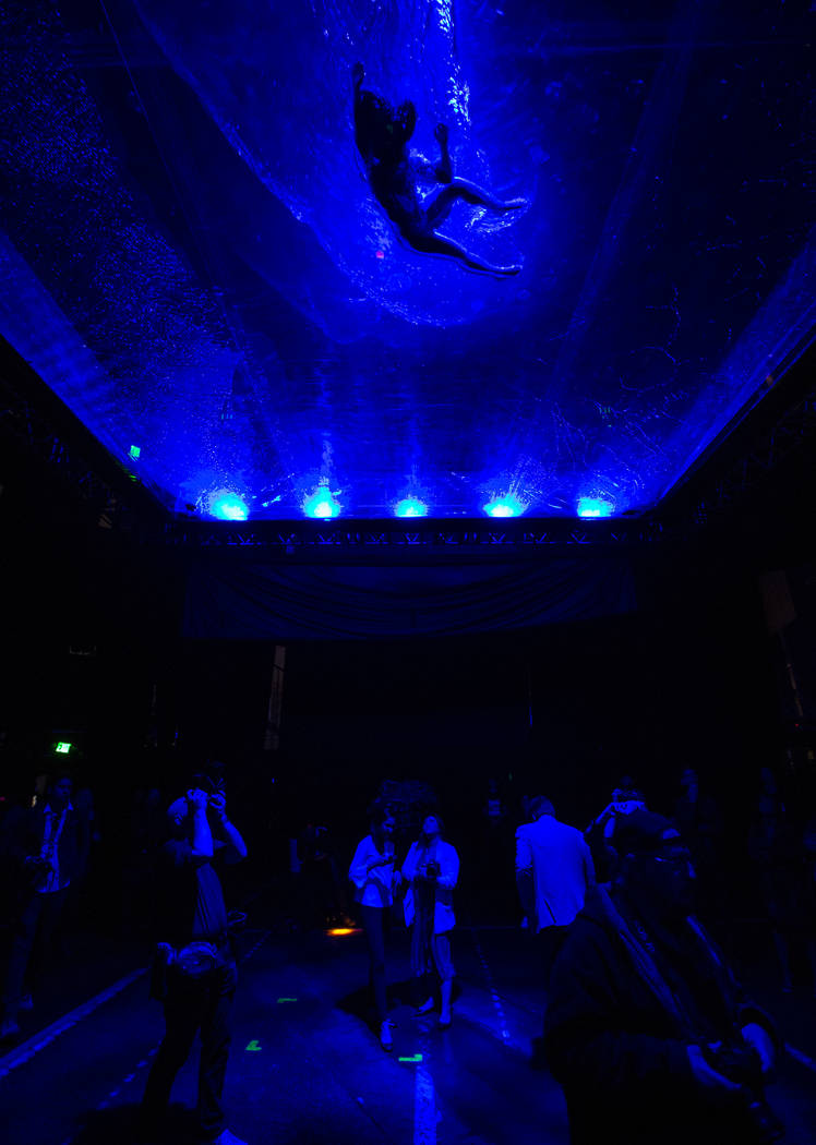 A cast members in "Fuerza Bruta" performs on a mylar suspended pool as part of a medi ...