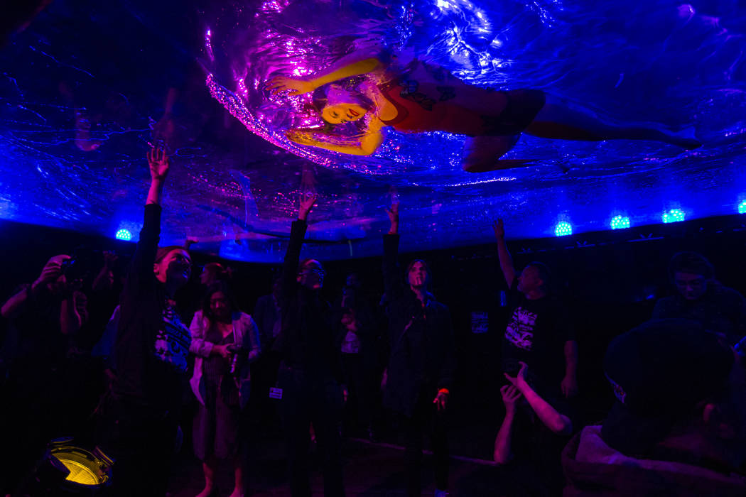 A cast members in "Fuerza Bruta" performs on a mylar suspended pool as part of a medi ...