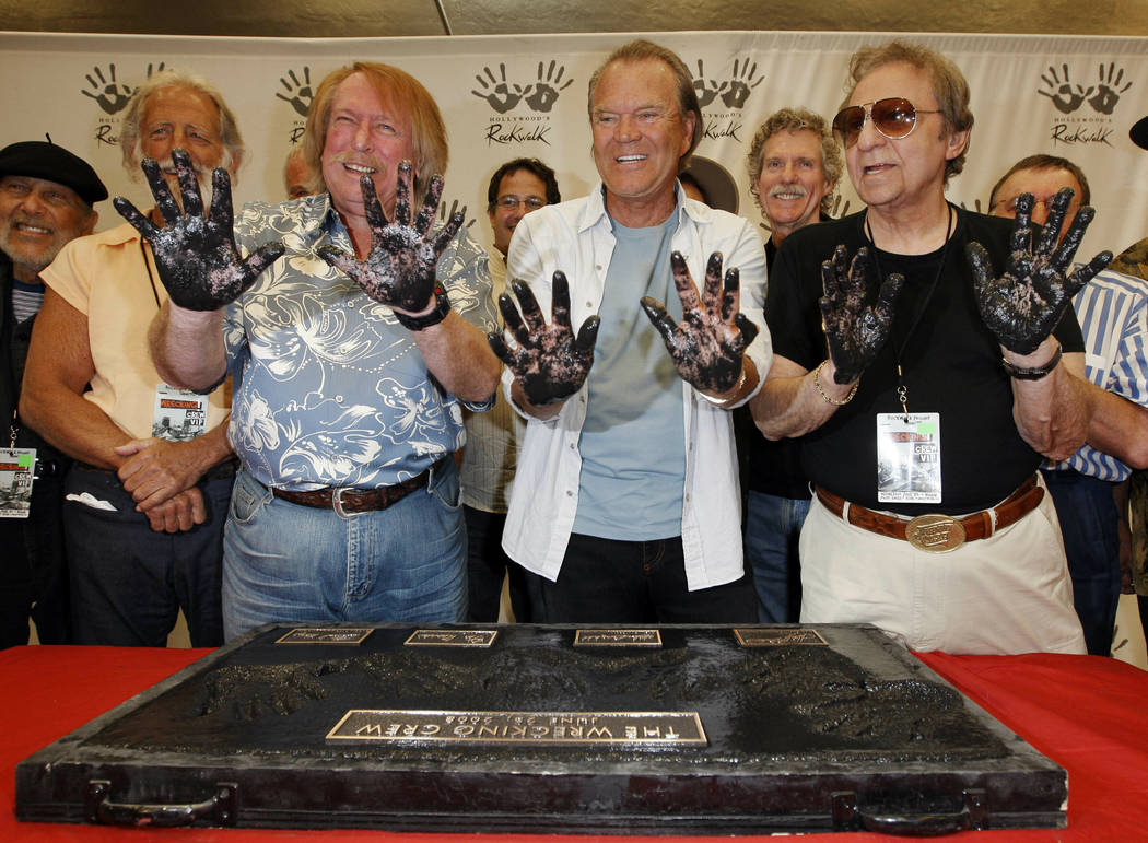 In this June 25, 2008, file photo, Don Randi, from left, Glen Campbell and Hal Blaine, representing session musicians known as The Wrecking Crew, hold up their hands after placing them in the ceme ...