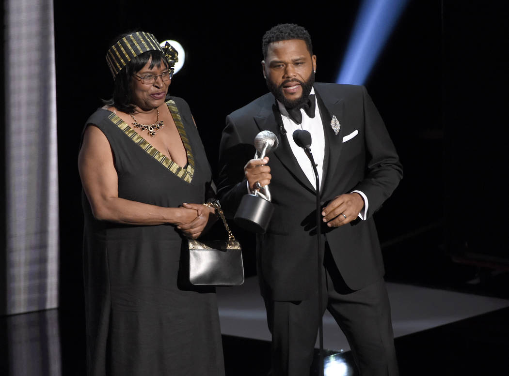 Anthony Anderson, right, accepts the award for outstanding actor in a comedy series for "b ...