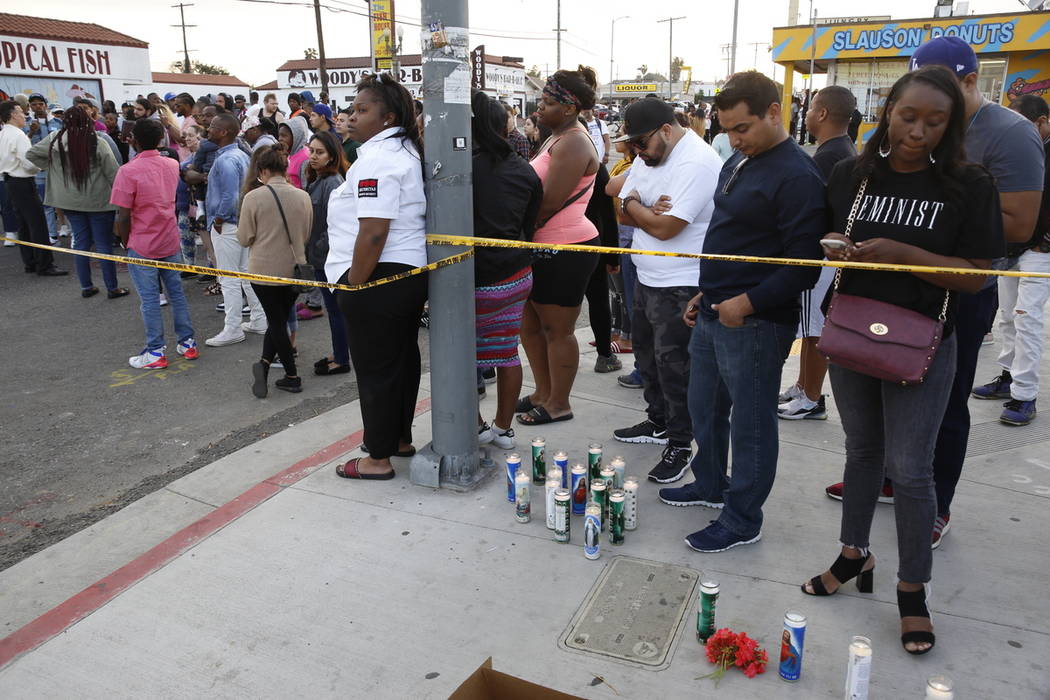 People set candles behind police yellow tape next to the Marathon Clothing store of rapper Nips ...