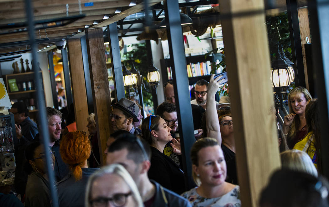 Guests explore all the new sections, books and merchandise for sale during the grand opening of ...