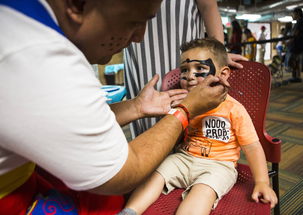 Marco Chavez paints the face of Gabriel Fernandez, 2, during the 10th annual Dia del Nino event ...