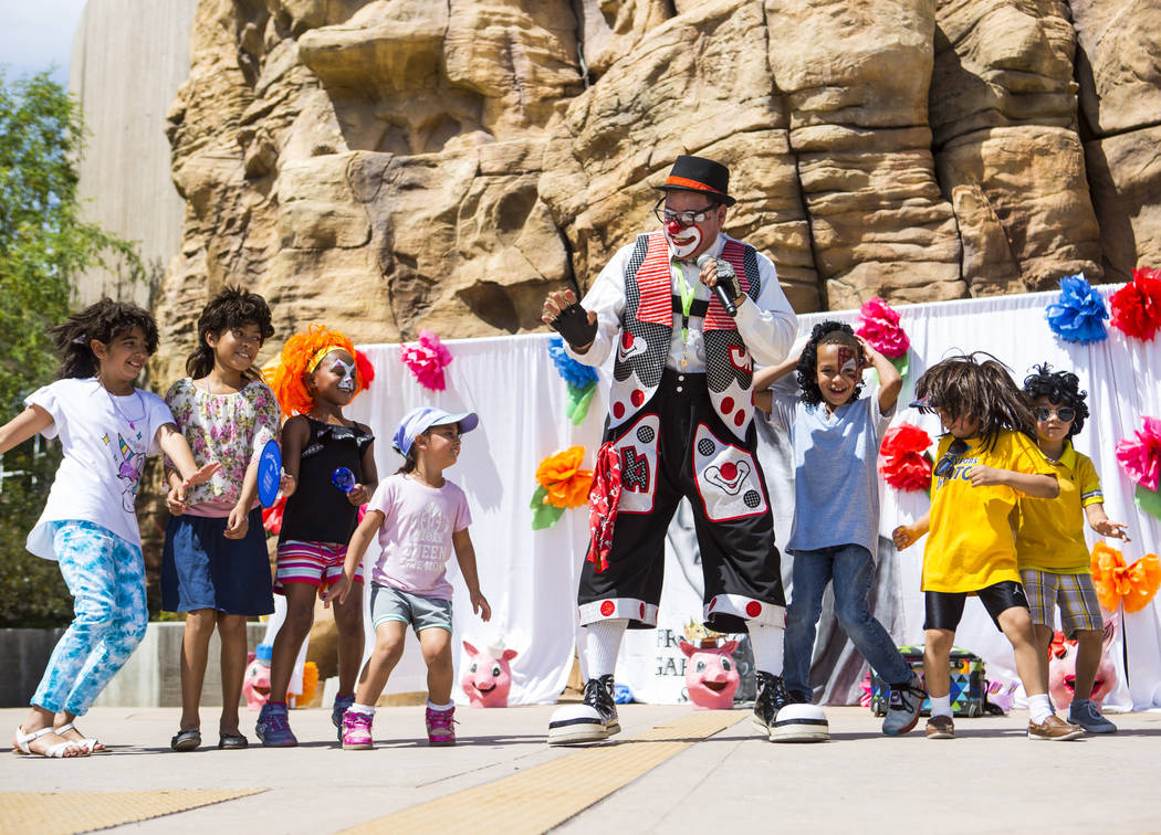 Chirolito the clown leads children in a dance during the 10th annual Dia del Nino event at the ...