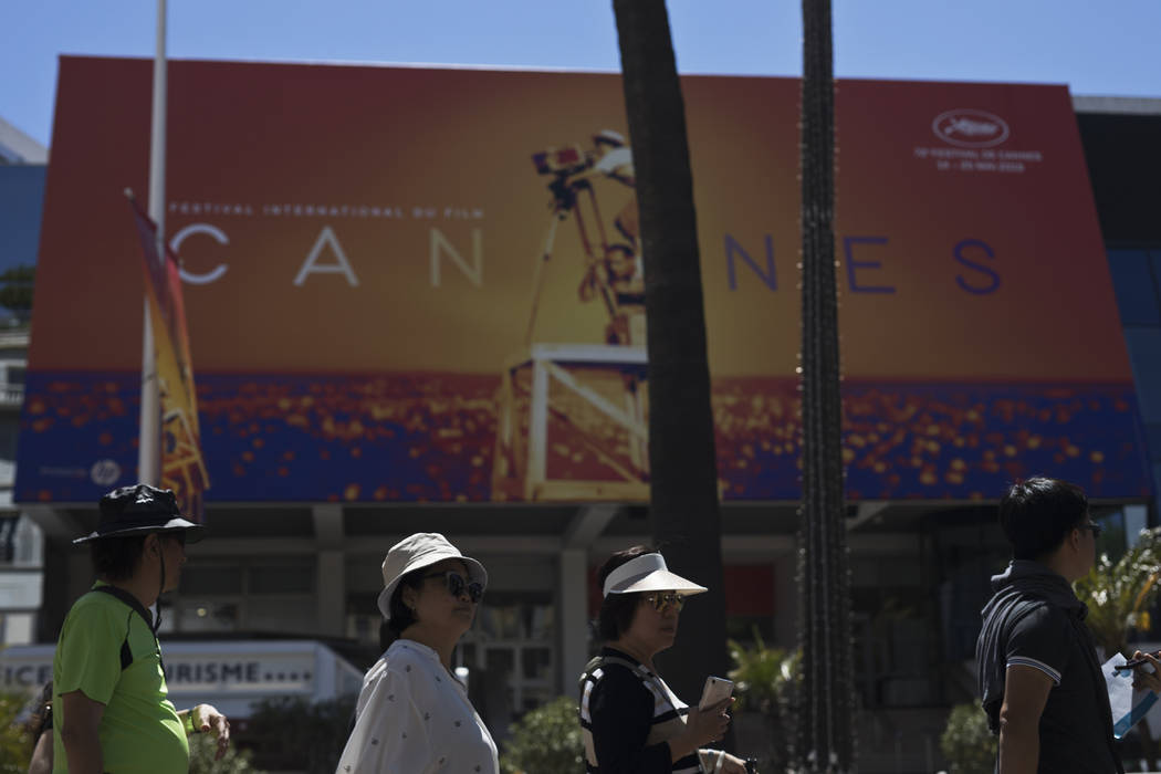 Festival goers walk by the Palais des festivals during the 72nd international film festival, Ca ...