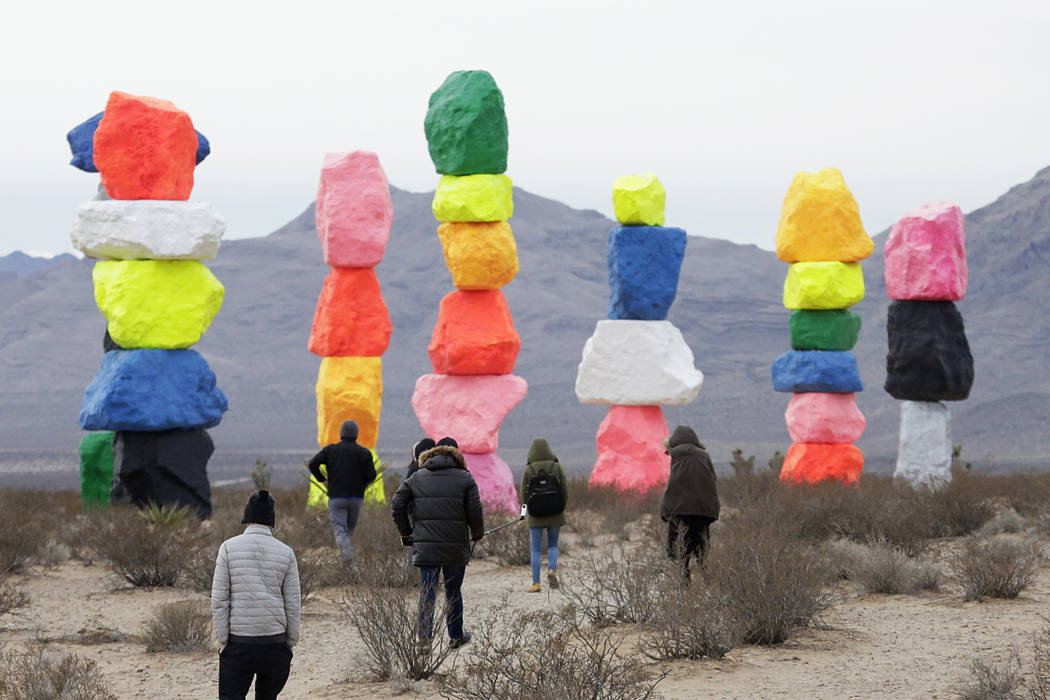 Tourists bundled up against the cold weather explore the area at Seven Magic Mountain near Jean ...