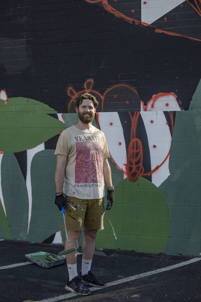 Artist Eric Vozzola stands in front of his mural-in-progress "An Allegory of Natural Beaut ...