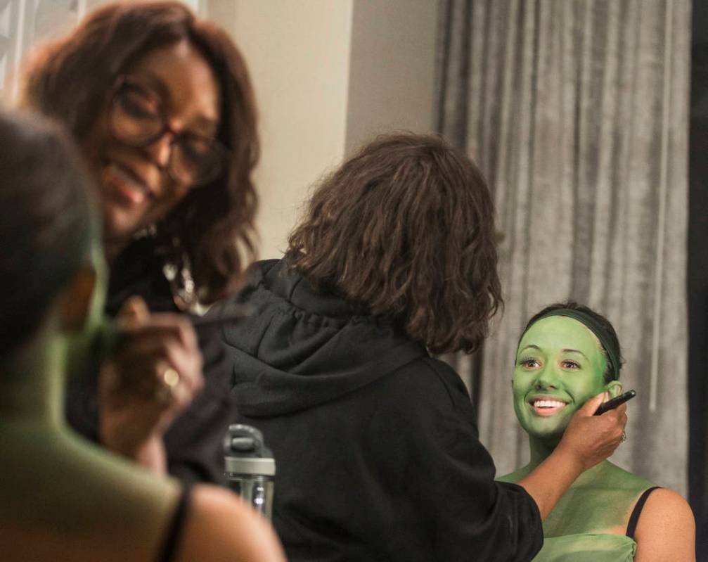 Mariand Torres, right, who plays Elphaba in "Wicked," gets her makeup done by makeup supervisor ...