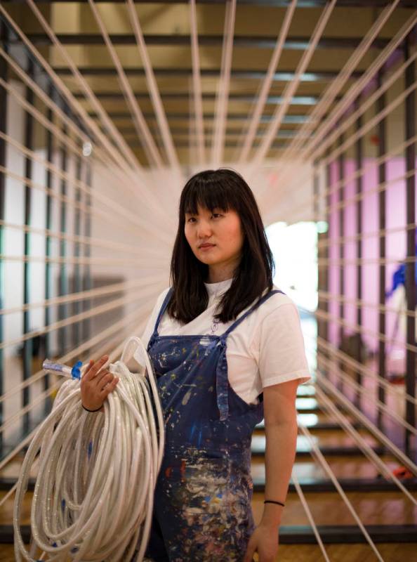 Amanda Phingbodhipakkiya, a neuroscientist-turned-artist, stands in front of one of her install ...