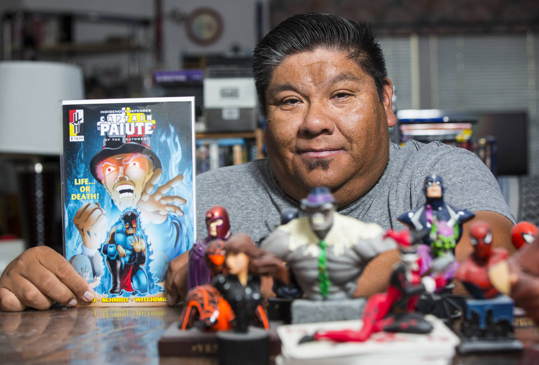 Theo Tso, creator of Captain Paiute, holds up a copy of "Captain Paiute: Indegenous Defend ...