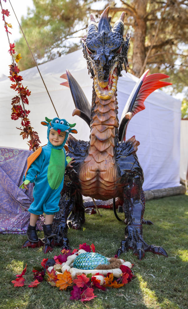 Eliana Green, 2, plays about a large dragon statue in the Greenwood Revelers encampment during ...