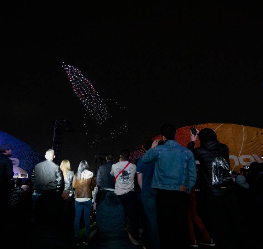 Festival-goers look up at The Expanse Drone Space Opera performance on Saturday, Dec. 7, 2019, ...
