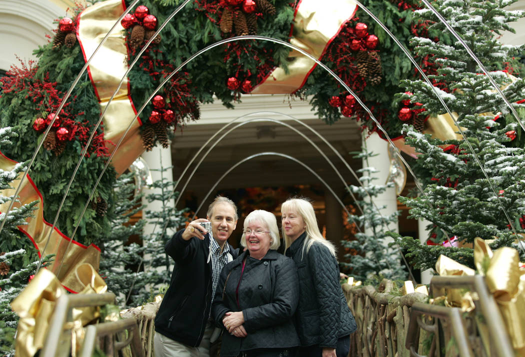 Alan Groves, left, takes a photograph of himself, friend Yvonne Lewis, center, and his wife Jul ...