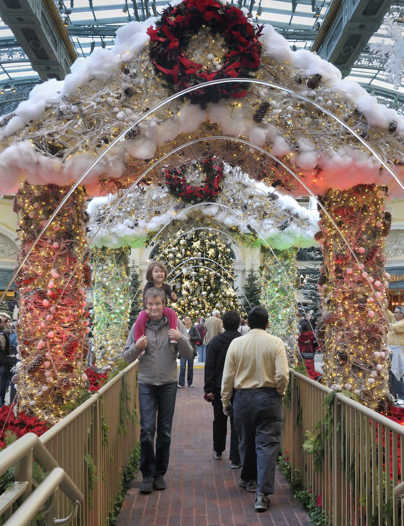 Las Vegas resident Robert Kilpatrick and his 3-year-old daughter, Marley, pass under decorated ...
