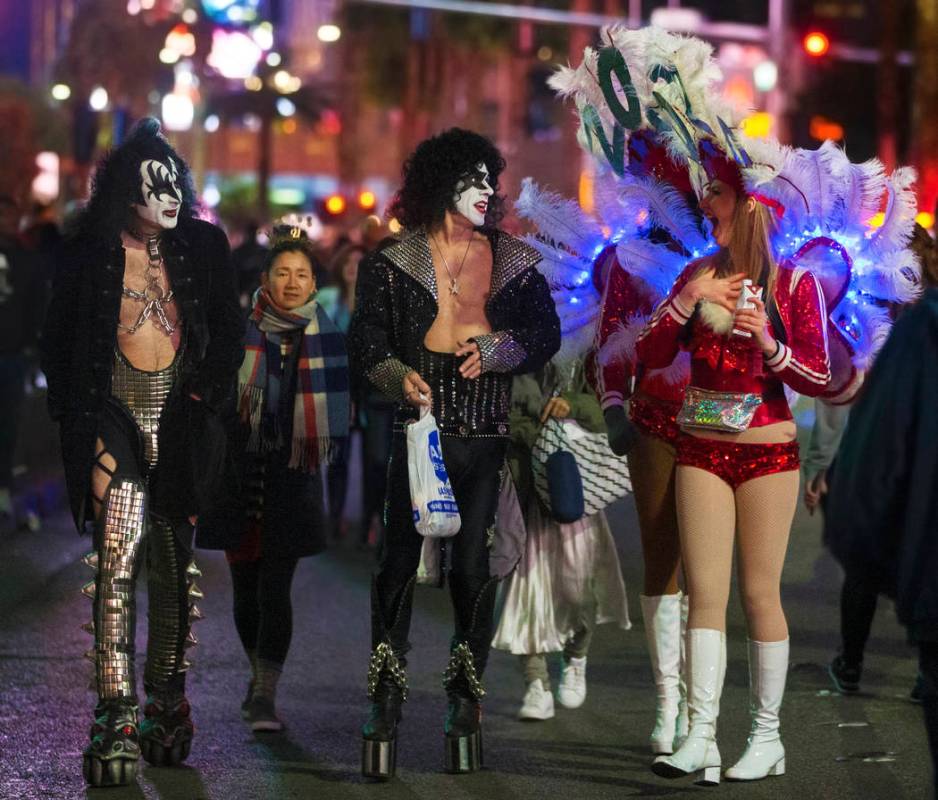 Show girls, right, share a moment with street performers dressed in Kiss attire on the Strip on ...