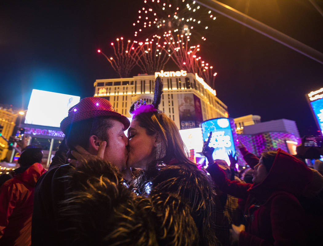 Moses Carpio, of Las Vegas, kisses his girlfriend Teresa Enriquez, of Juarez, on New Yearȁ ...