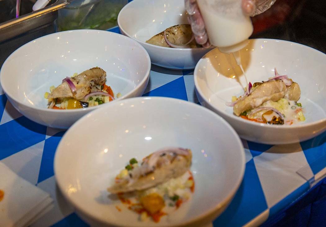 Chef Khaddy Dublin, Chef Battle San Diego winner, adds a sauce to her chicken afritada dish as ...