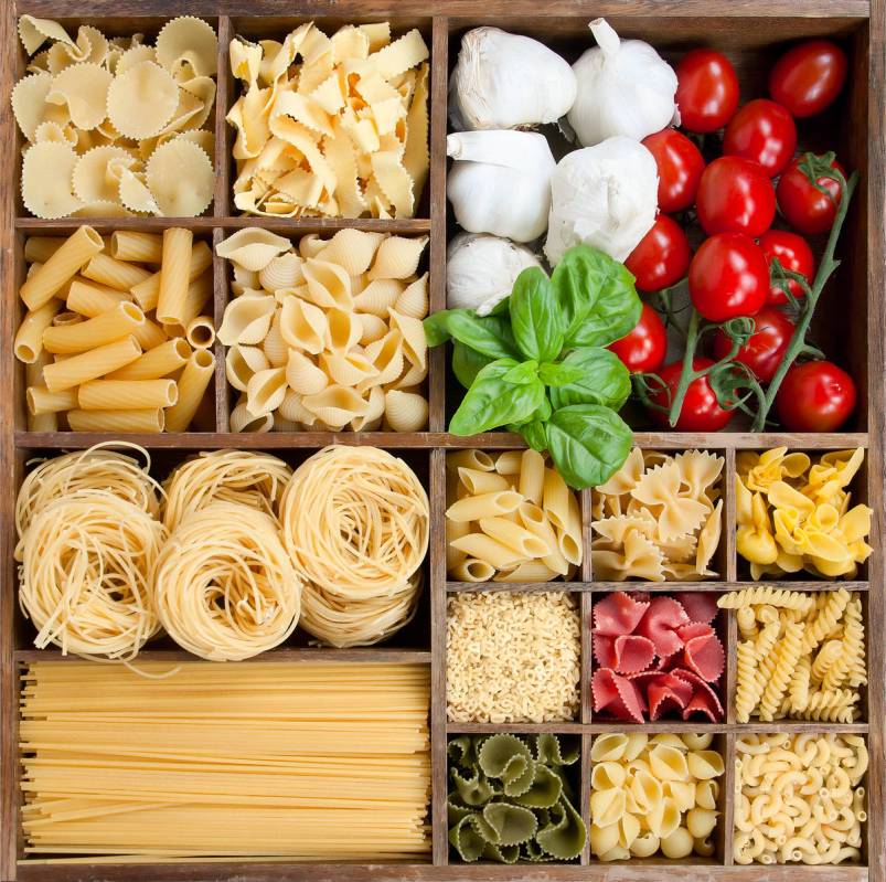 Assorted pastas in wooden box with cooking ingredients