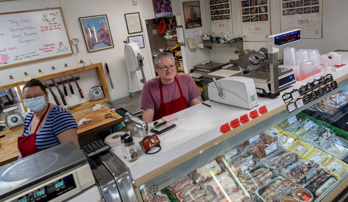 Village Meat & Wine employee Allison Hall-Stith, left and owner Tim Jensen help a customer ...
