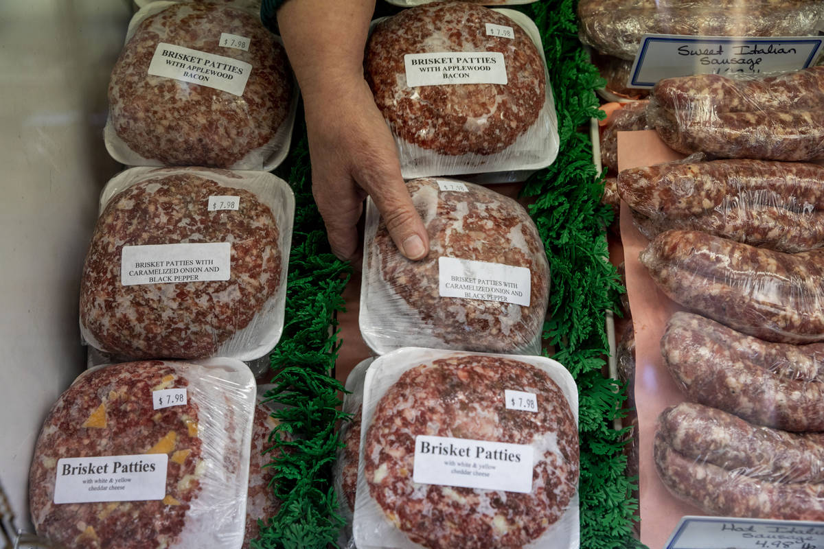 Brisket patties are retrieved for a customer at Village Meat & Wine, an old fashioned butch ...