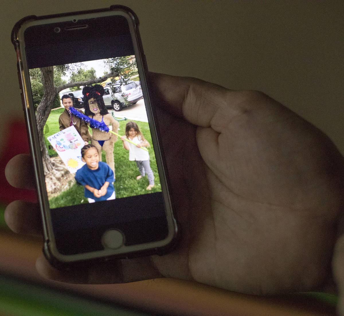Omar Soto holds his phone with a photo of Kourtney Kardashian and the replica pinata he created ...