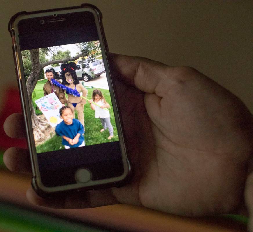 Omar Soto holds his phone with a photo of Kourtney Kardashian and the replica pinata he created ...