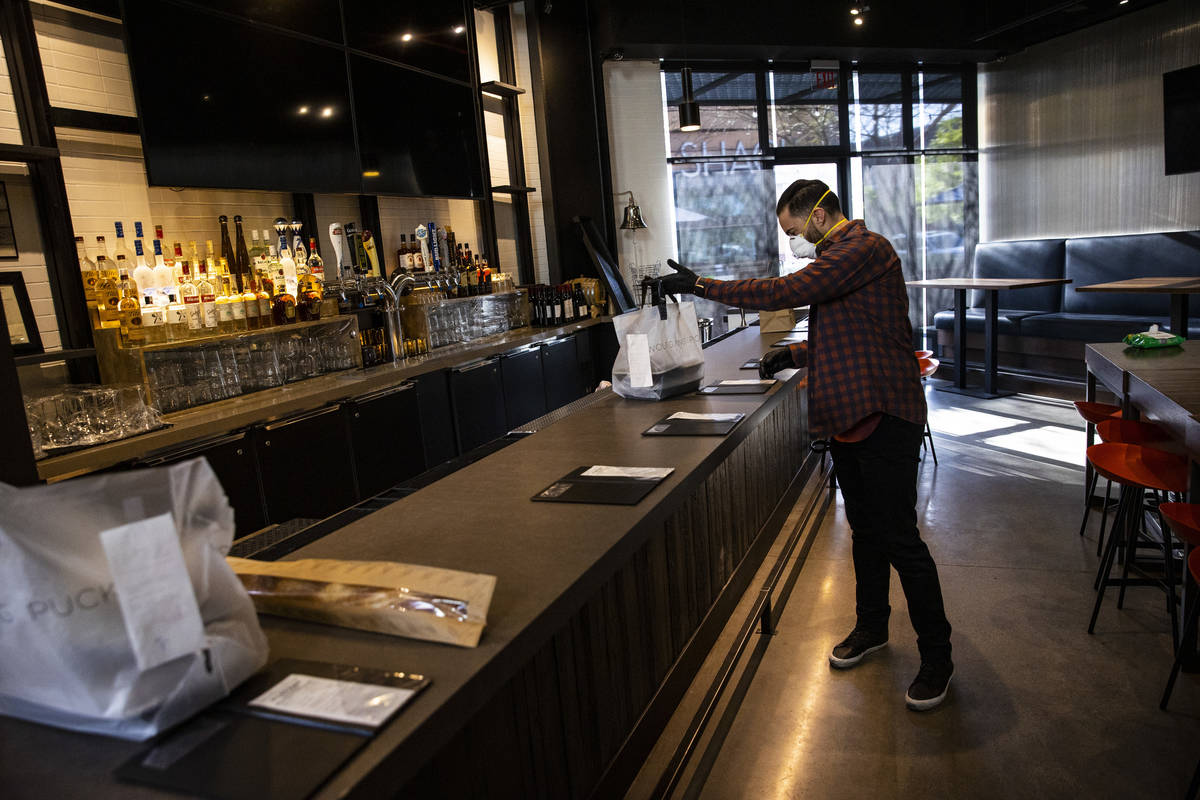 Brad Street, general manager of Lupo by Wolfgang Puck, prepares takeout orders at Wolfgang Puck ...