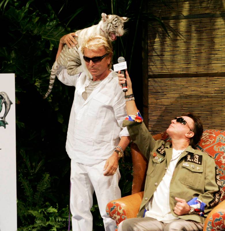 Siegfried Fischbacher, left, holds "Star," a 12-week-old female white tiger, as his show busine ...
