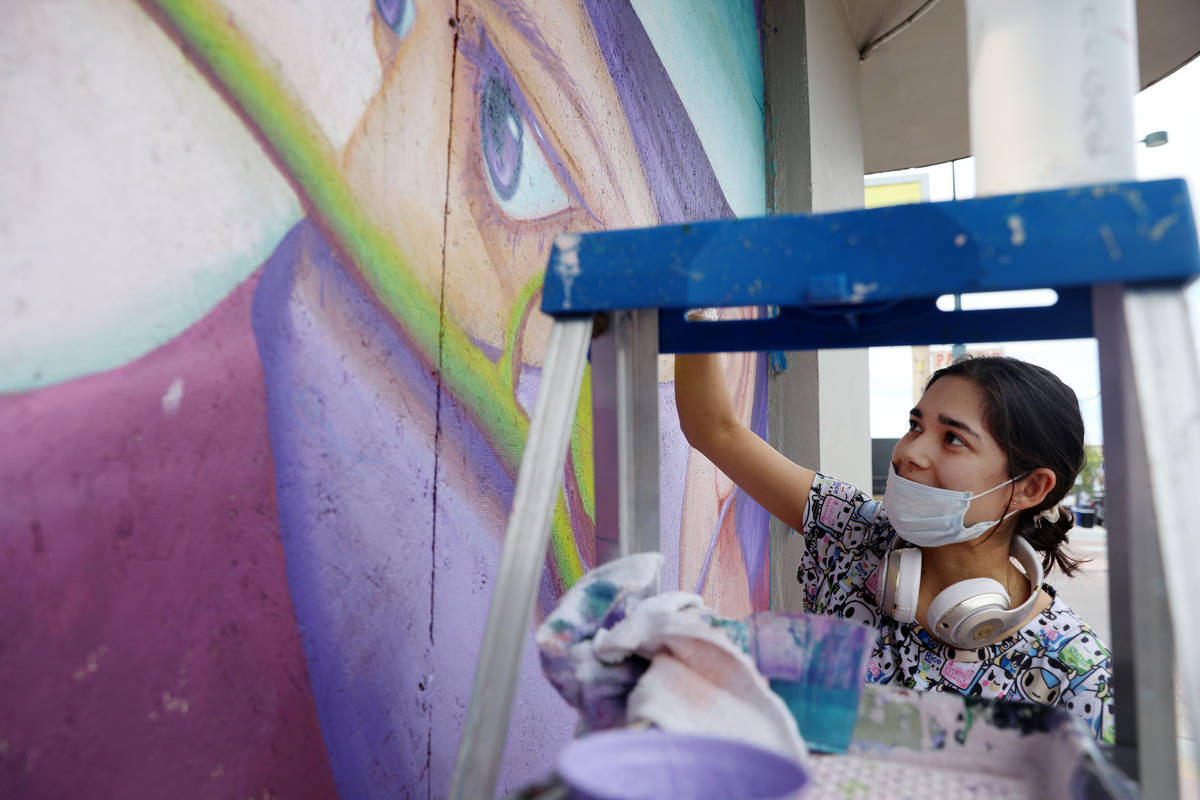 Chelsea Rust, muralist and staff of Priscilla Fowler Fine Art, paints a mural of a Las Vegas Va ...