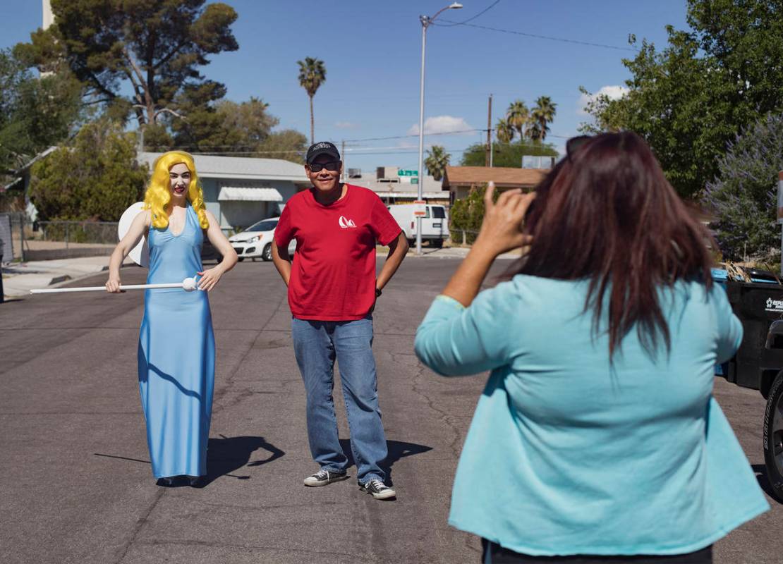 Victoria Hogan, dressed as the Blue Angel statue from the former Blue Angel Motel, takes a phot ...