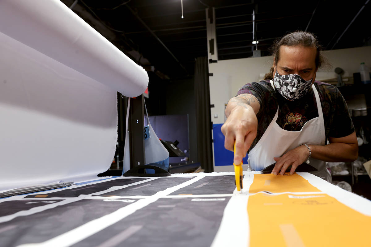 Former chef Jean Paul Labadie, creator of ApronTie, cuts fabric to make his product for chefs a ...