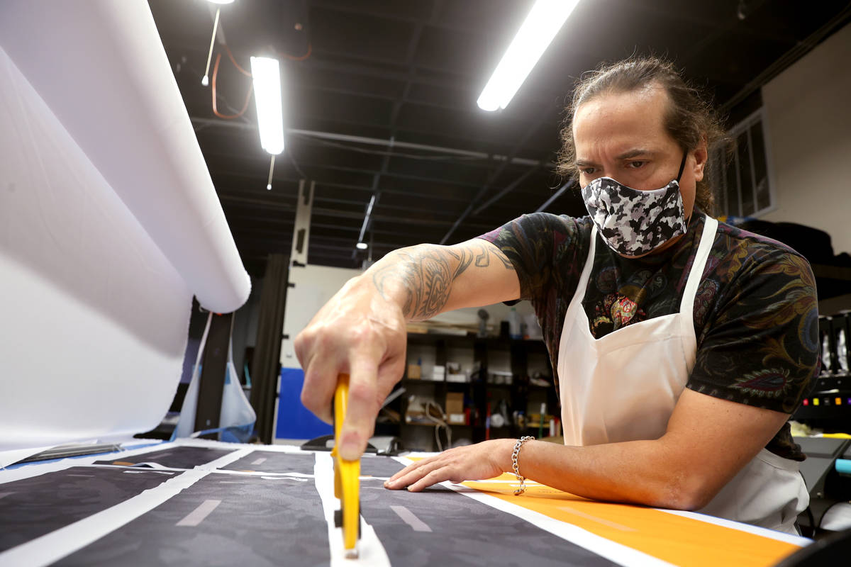 Former chef Jean Paul Labadie, creator of ApronTie, cuts fabric to make his product for chefs a ...