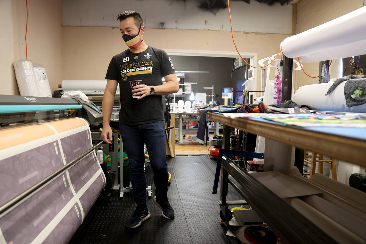 Glenn Adams, co-owner of ApronTie, monitors a printout of apron patterns for his product for ch ...