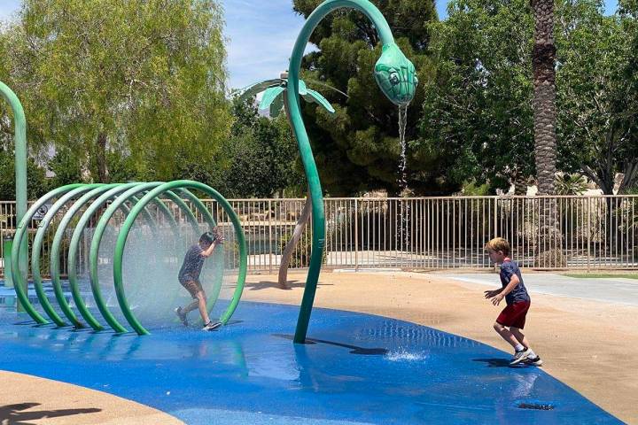 Children running through sprinklers at Aliante Nature Discovery Park's splash pad as it reopene ...