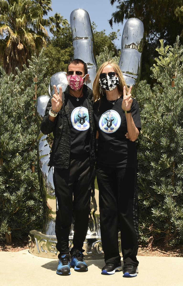 Musician Ringo Starr and his wife Barbara Bach pose together in front of his "Peace and Lo ...