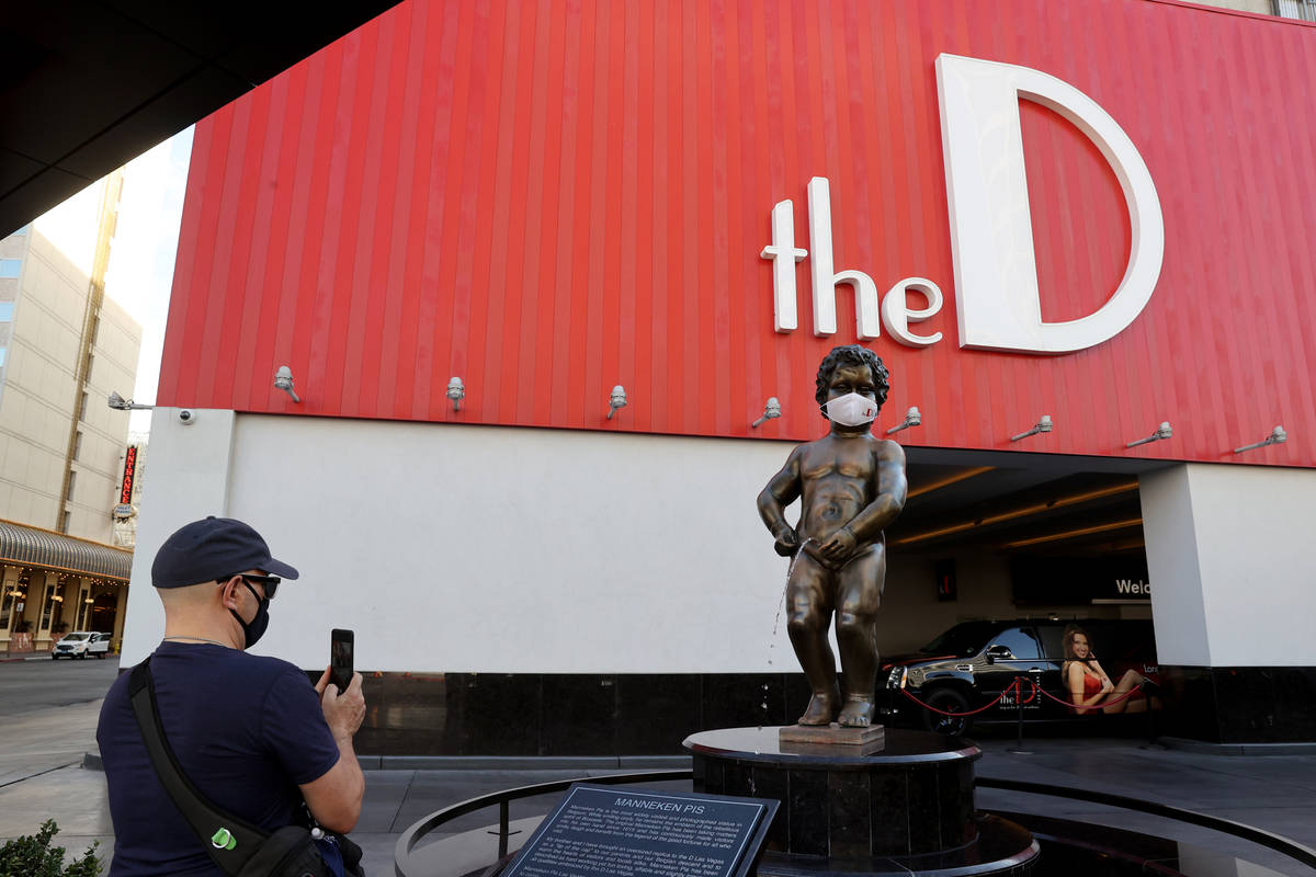 Avante Williams, a native of Detroit who now lives in Las Vegas, takes a photo of Manneken Pis ...