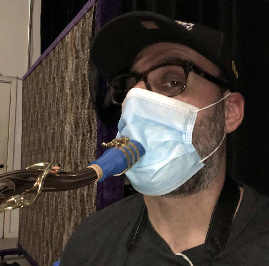 Las Vegas musician Jon Celentano of The Windjammers works around a face mask during a rehearsal ...
