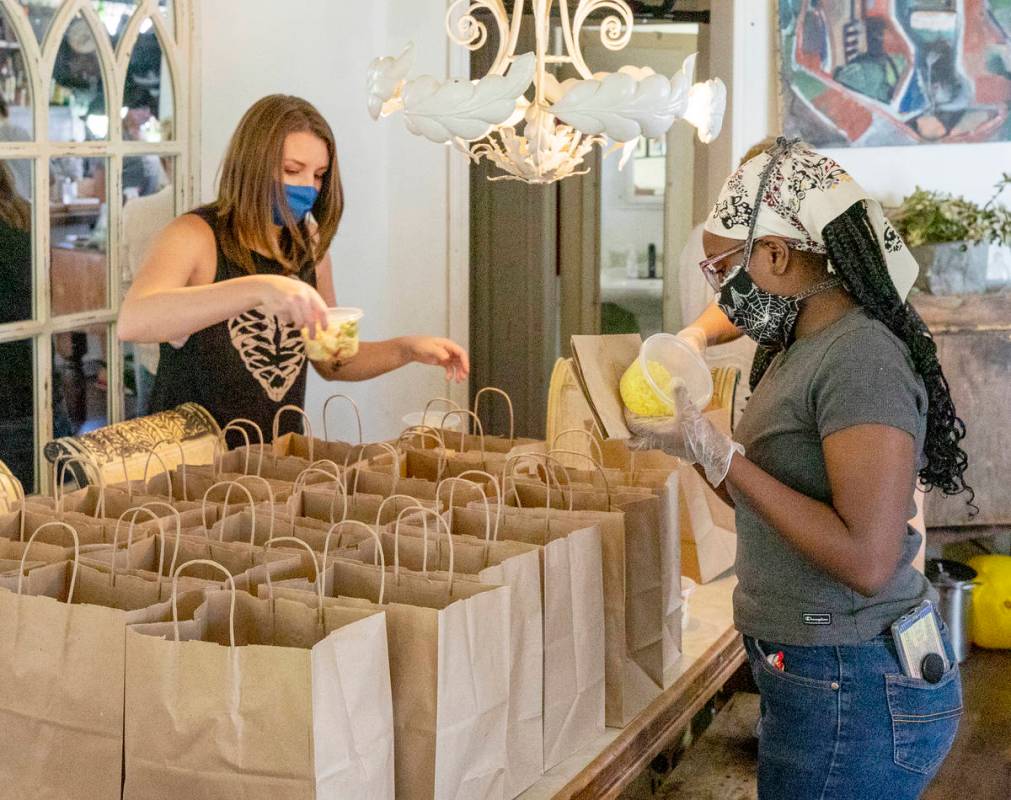 Volunteers Kayla Everly, left, and Relariel Hall, prepare meals at Kim Foster's home in Las Veg ...