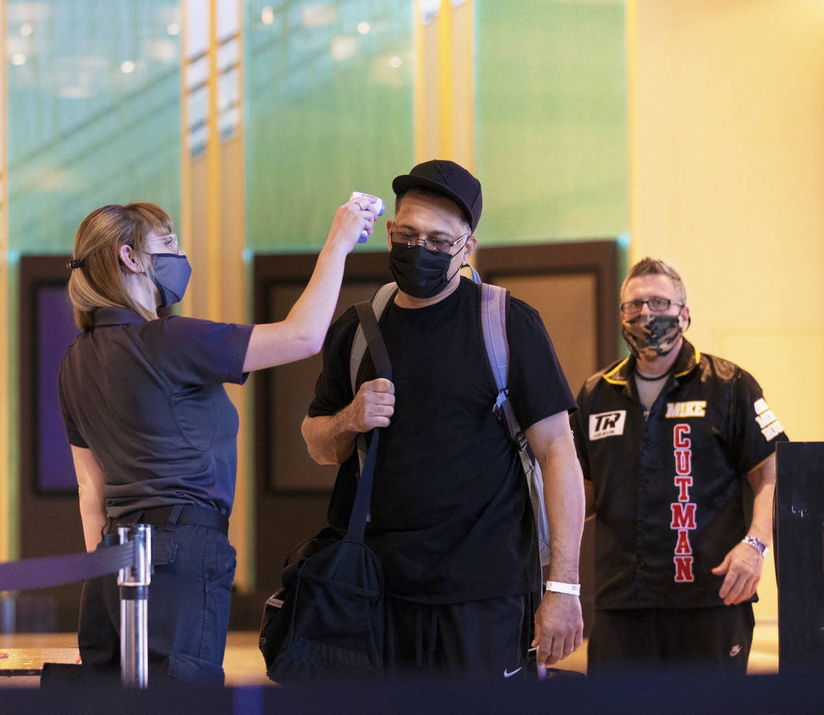 Emergency medical technician Megan Meyer, left, takes the temperature of Bob Ware as he enters ...