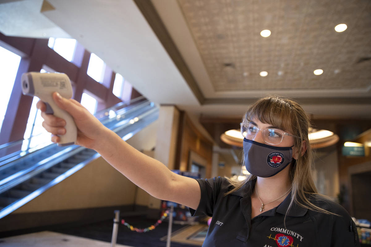 Emergency medical technician Megan Meyer takes the temperature of staff as they enter the MGM C ...