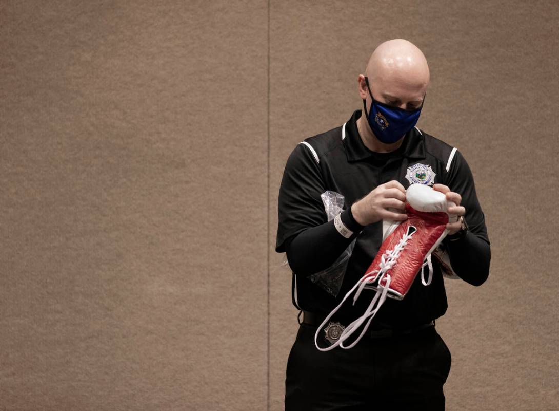 Scott Koenig, with the Nevada State Athletic Commission, inspects a newly unpackaged pair of bo ...