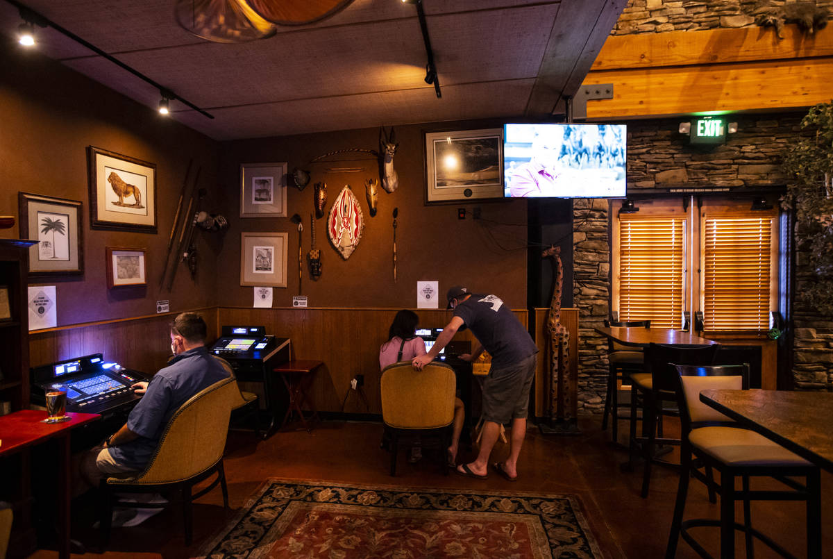 Kelly and Pete, center, who declined to give their last names, play on gaming machines that wer ...
