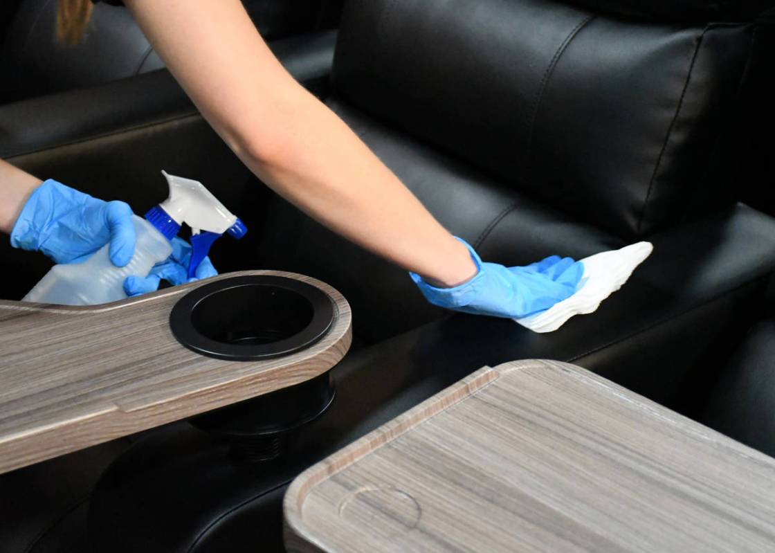 A Cinemark employee cleans inside an auditorium. Five Century-branded movie theaters operated b ...