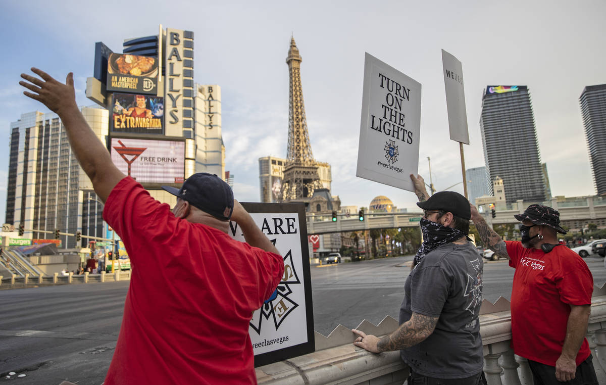 Entertainment workers waive to passing traffic during an event to raise awareness about the pli ...