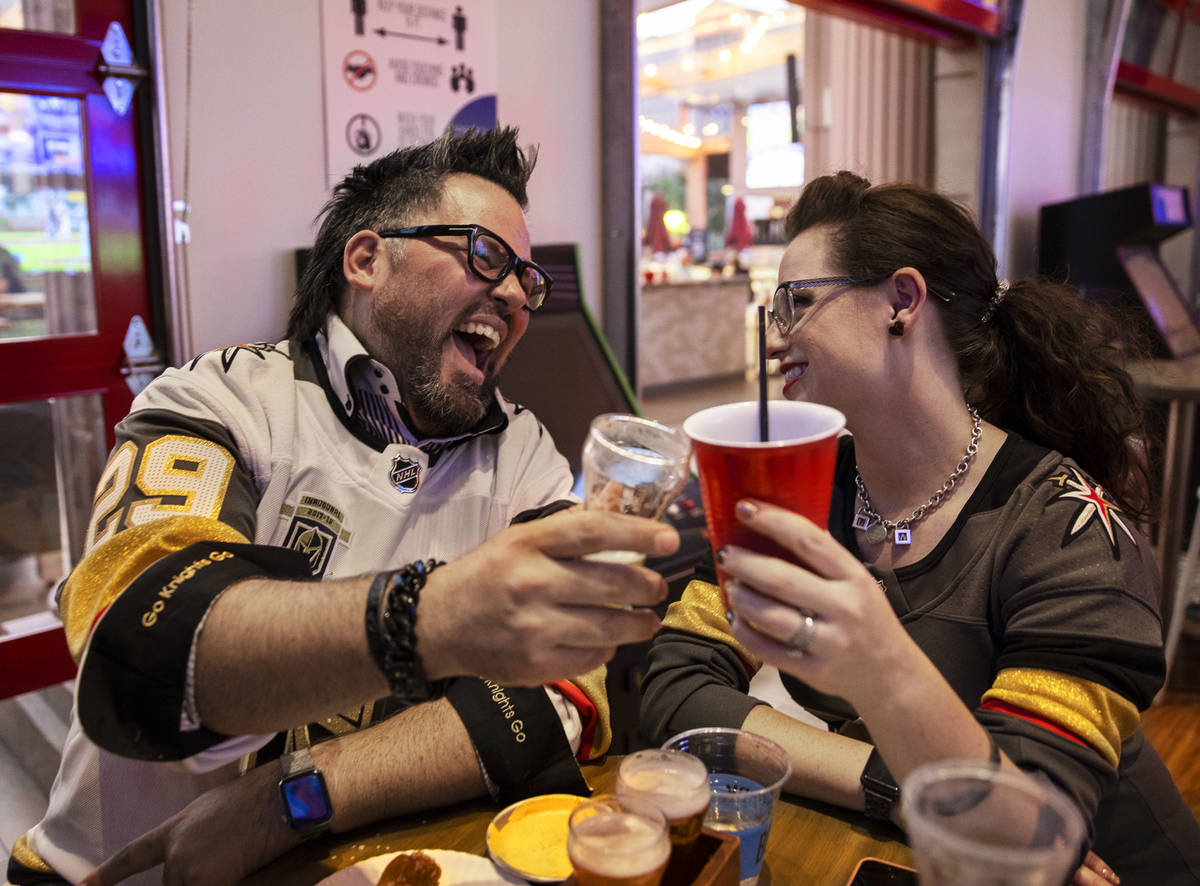 Will and Jenny Ayces, from Anaheim, Calif., celebrate during the Golden Knights NHL playoff hoc ...