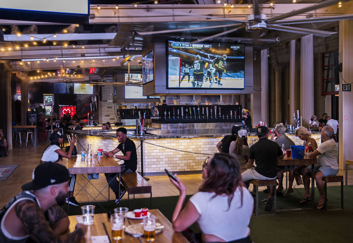 Hockey fans watch the Golden Knights play the Vancouver Canucks during an NHL playoff hockey ga ...