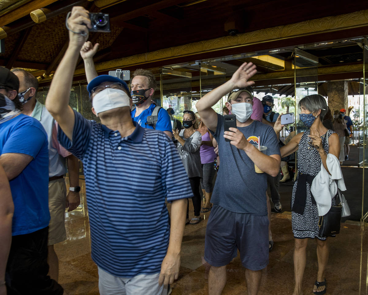 Guests celebrate and document while entering the front doors as the Mirage reopens following a ...