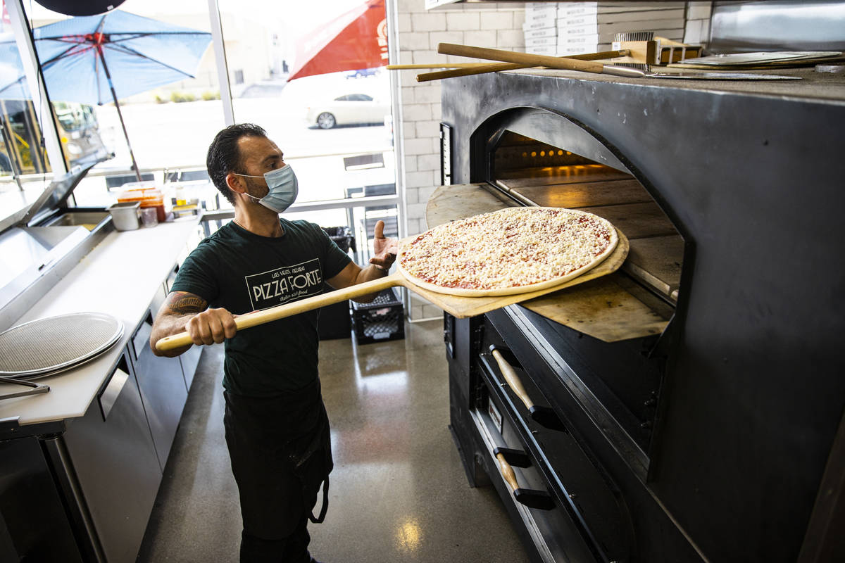 Mimmo Ferraro, owner and chef at Pizza Forte, right, prepares a pizza in the University Gateway ...